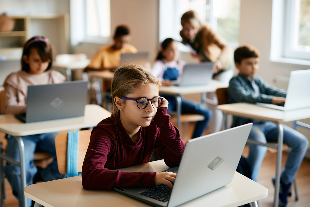 Estudiantes usando HelpNDoc para aprendizaje electrónico con un portátil en un aula